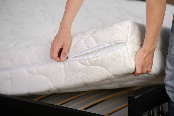 zipping the mattress pad to prevent dust mites